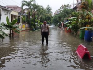 Bhabinkamtibmas Polsek Rawa Lumbu Aiptu Ujang Herlan Pantau Genangan Air dan Akses Jalan di Wilayah Binaan